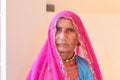 An indian elderly woman sitting in a pinkish red veil Royalty Free Stock Photo